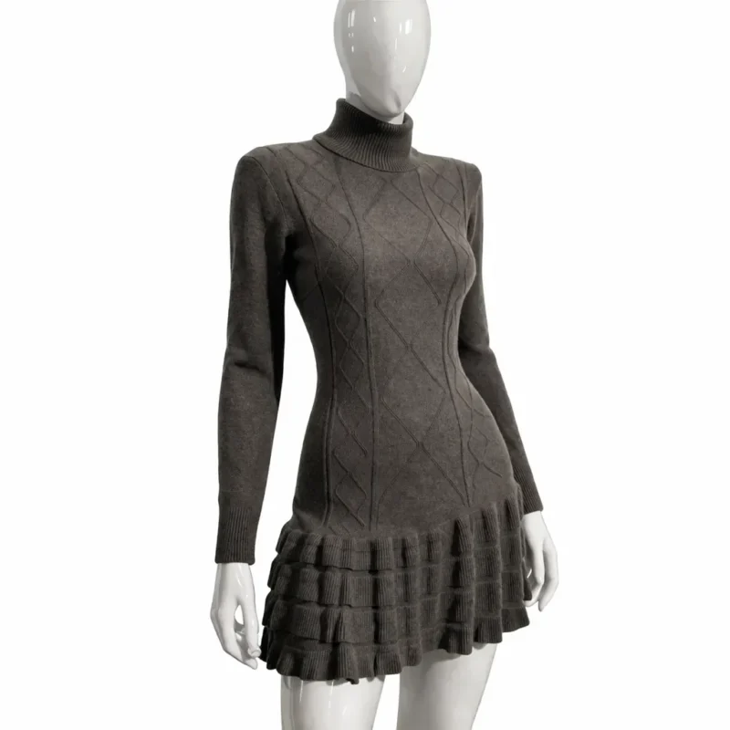 Дамска плетена туника с поло яка в тъмен нюанс с релефна шарка и къдрава долна част, показана върху манекен отпред