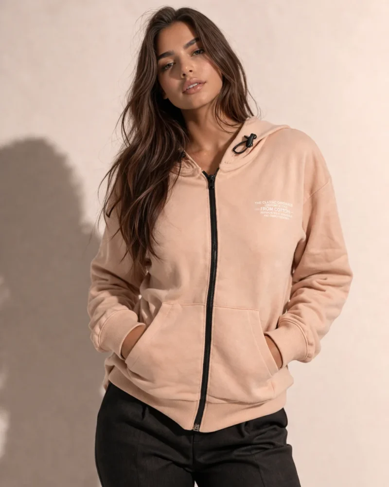 Дамски розов суичър с цип и качулка, с предни джобове и връзки на качулката, носен от модел отпред