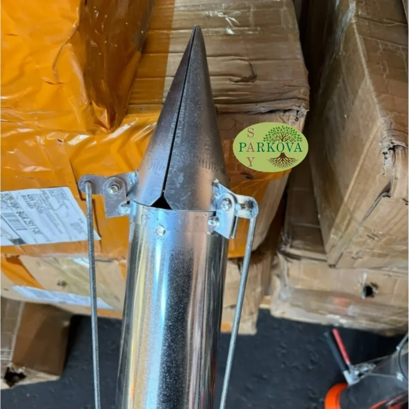 Показан е върха на машината за садене на разсад, който се забива в почвата отблизо.