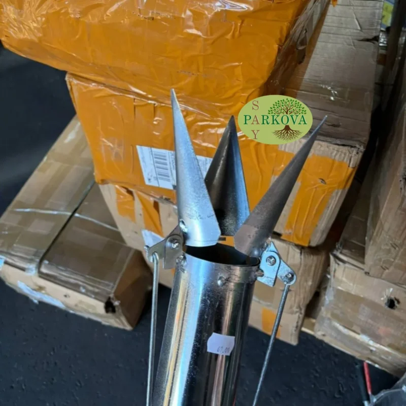 Показан е отвореният връх на машината за садене на разсад, който се забива в почвата отдалеч.